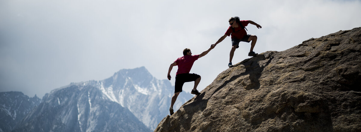 Bergsteiger helfen sich gegenseitig beim Aufstieg